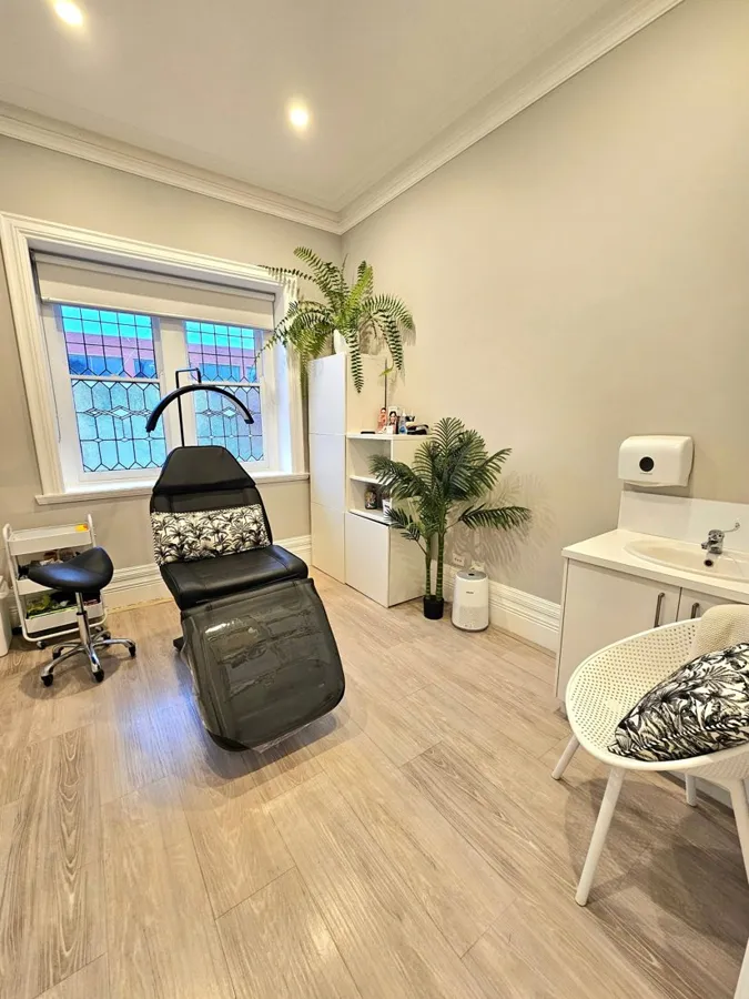 Skin treatment room with treatment chair and handbasin